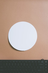 Top view of keyboard on creamy brown colored background with white frame as copy space