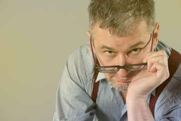 Writer with glasses and suspenders is thinking about his work