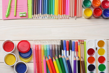 school and office supplies. school background. colored pencils, pen, pains, paper for  school and student education on wooden background. top view with copy space