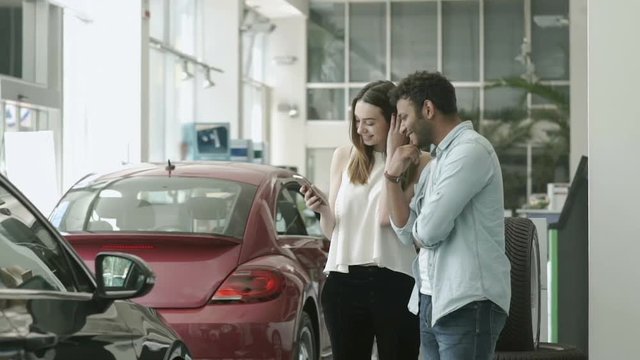 Young couple using a telephone in car showroom