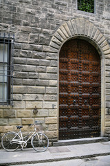 Fototapeta na wymiar bicycle near door of medieval house in Florence