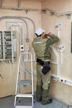 Electrician makes wiring for lighting