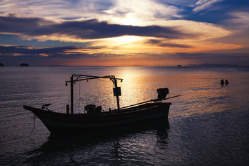 Sunset in Samui island with boat and couple in water