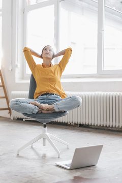 Yung woman sitting in her new flat with a laptop