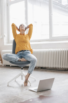 Yung woman sitting in her new flat with a laptop