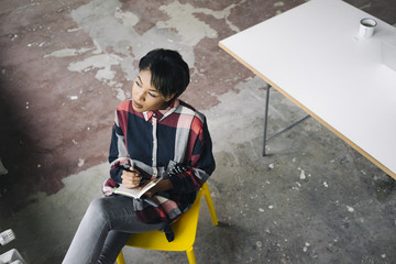 Woman sitting on chair with notebook