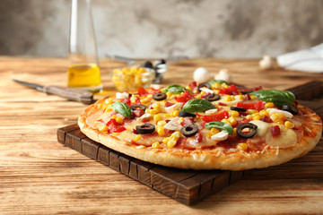 Tasty pizza and its ingredients on wooden table