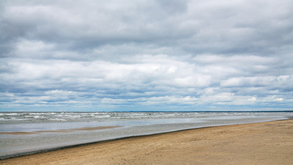 low gray clouds over beach of Baltic Sea in autumn