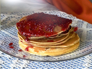 Jam and pancakes are on the plate.