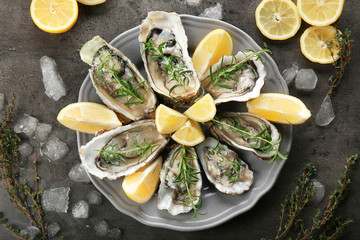 Tasty fresh oysters with sliced lemon on plate. Aphrodisiac food for increasing sexual desire