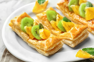 Delicious pastries with fruits and honey on plate, closeup