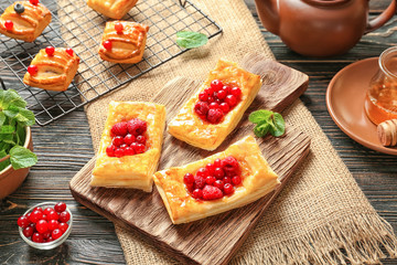 Cutting board and baking rack with pastries on wooden table