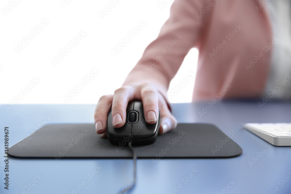 Wall mural Female hand holding computer mouse on pad