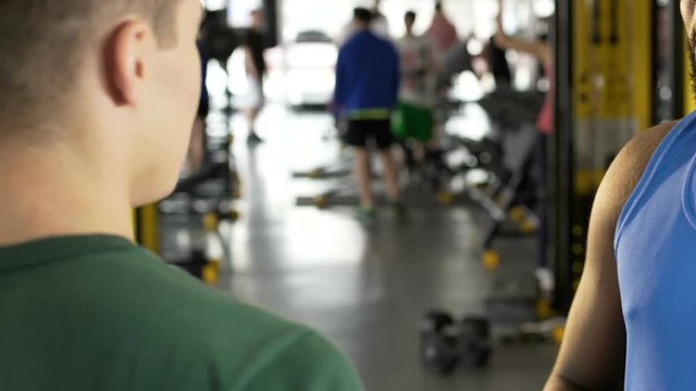 Two guys talking to each other in gym, international communication, friends