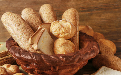 Baked basket with fresh bread on wooden background