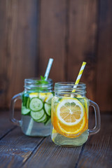 Detox water with cucumber, lemon and mint. Lemonade with orange. Wooden background. The concept of a diet, a vegetarian, healthy food and a lifestyle.