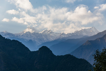 Kangchenjunga mountain with clouds above. Among green hills that view in the evening in North Sikkim, India.