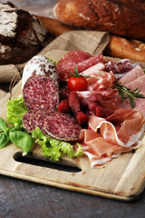 Food tray with delicious salami, pieces of sliced ham, sausage,