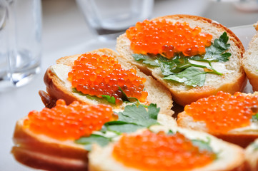 Photo of baguette with red caviar on white table