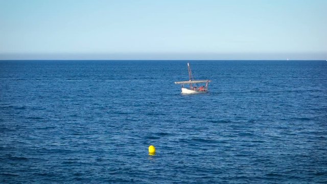 Traditional mediterranean vessel named Llagut sailing in the wind through the waves.