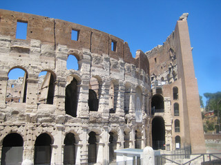 Fototapeta premium Colosseum or Coliseum (Flavian Amphitheatre) historic monument in Rome, Italy. World largest ancient amphitheatre built of concrete and sand. View of old fracture breaking walls