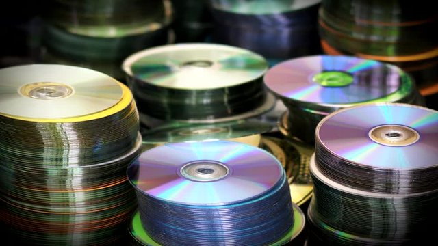 Blur View of Compact Optical Dvd or cd Discs Piles Standing on Table