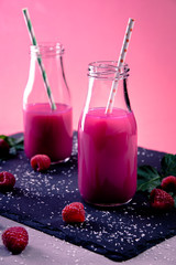 Himbeer Smoothie mit Strohhalm auf Schieferplatte vertical