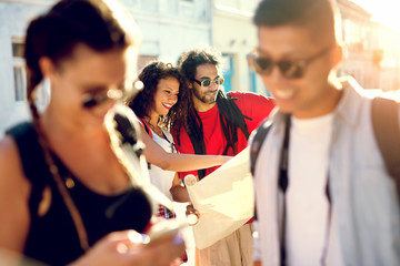  Multiracial couples exploring a city, happy tourists discovering new locations looking at map.