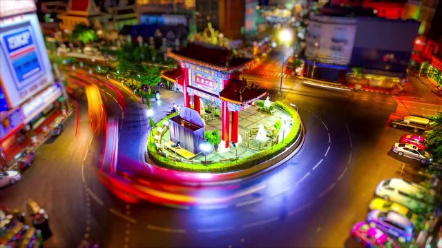 Traffic in roundabout surrounding Victory Monument at night in Bangkok, Thailand, timelapse (blurred logos for commercial use)