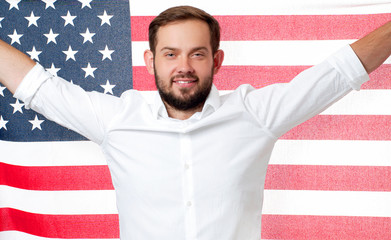 Smiling patriotic man holding United States flag. USA celebrate 4th July.