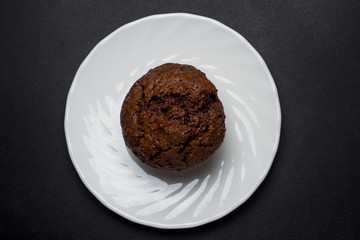 Chocolate muffin on white saucer