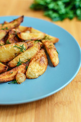 Roasted potatoes with salt pepper and cumin on wooden background