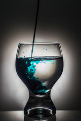 Glass of water with splash green dye