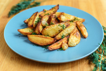 Roasted potatoes with salt pepper and cumin on wooden background