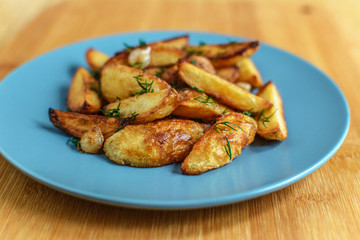 Roasted potatoes with salt pepper and cumin on wooden background