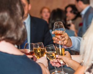 People clink glasses with various alcoholic beverages