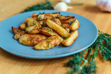 Roasted potatoes with salt pepper and cumin on wooden background