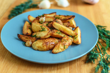Roasted potatoes with salt pepper and cumin on wooden background