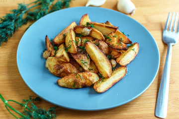 Roasted potatoes with salt pepper and cumin on wooden background