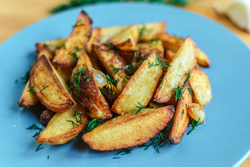Roasted potatoes with salt pepper and cumin on wooden background