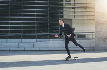 Businessman on a skateboard in urban area