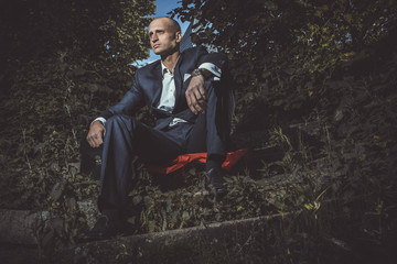 Serious man sitting on a old broken stairs
