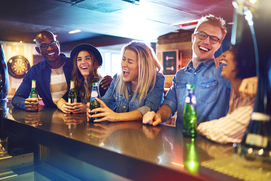 Laughing Group Of People Drinking In Tavern