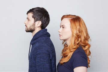 Trust and devotion concept. Redhead freckled Caucasian woman is looking the same direction as her boyfriend.