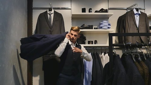 man put coat on shoulder at clothing store, slow motion