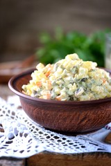 Traditional Russian salad Olivier on an old wooden background. Russian kitchen. Rustic style.