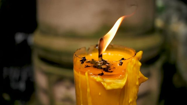 High large yellow candle burns in Wat Saket (Golden Mount). Bangkok, Thailand.