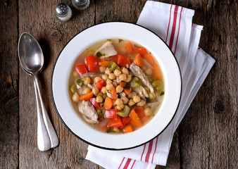 Soup with chicken, chickpeas, sweet peppers, onions, carrots, celery and parsley. Healthy food.