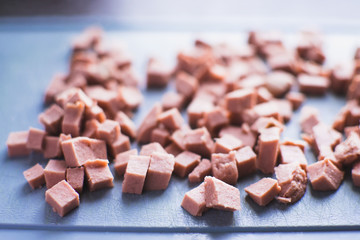 sausage cut by cubes, on a blue Board