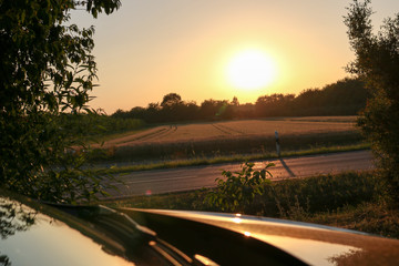 Fototapeta premium Auto parkt bei Sonnenuntergang an Landstraße 3
